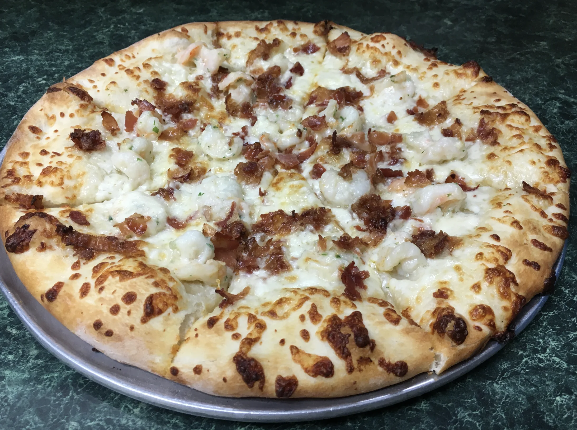 White pizza topped with shrimp and crisp bacon